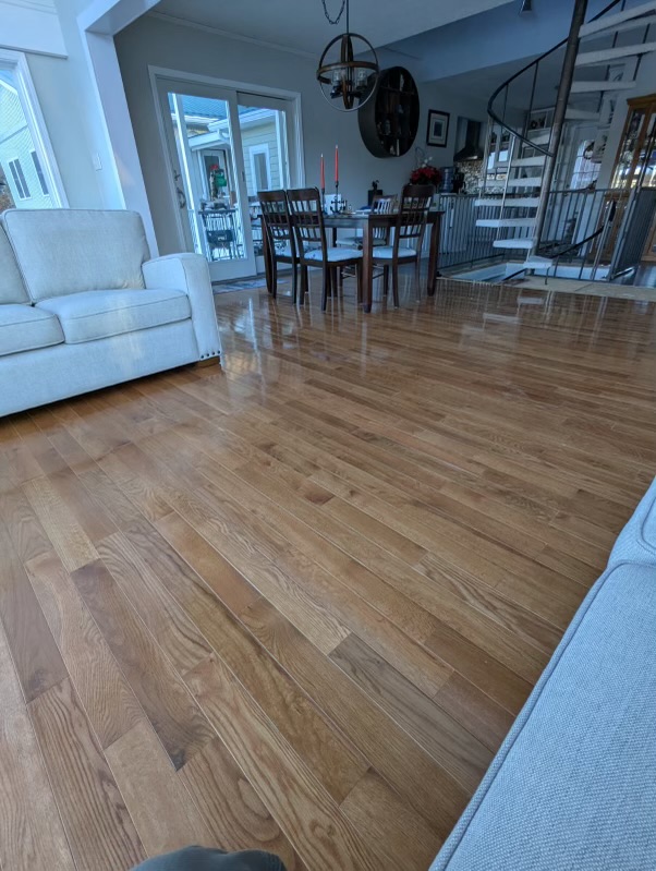 Character Natural Red Oak flooring in a living room with a white sofa, dining set, and spiral staircase.