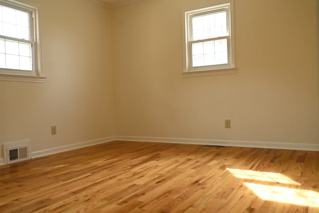 Character Golden Oak prefinished Red Oak flooring in a sunlit bedroom with neutral walls and white trim.