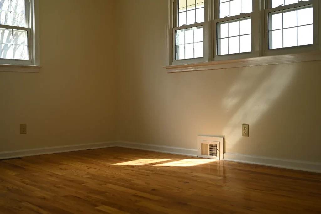 Character Golden Oak prefinished Red Oak flooring featured in a sunlit bedroom with neutral walls.