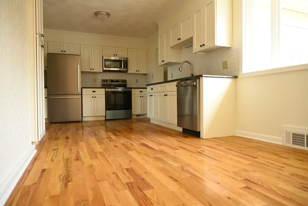 Character Golden Oak prefinished Red Oak flooring in a kitchen with white cabinets and stainless steel appliances.