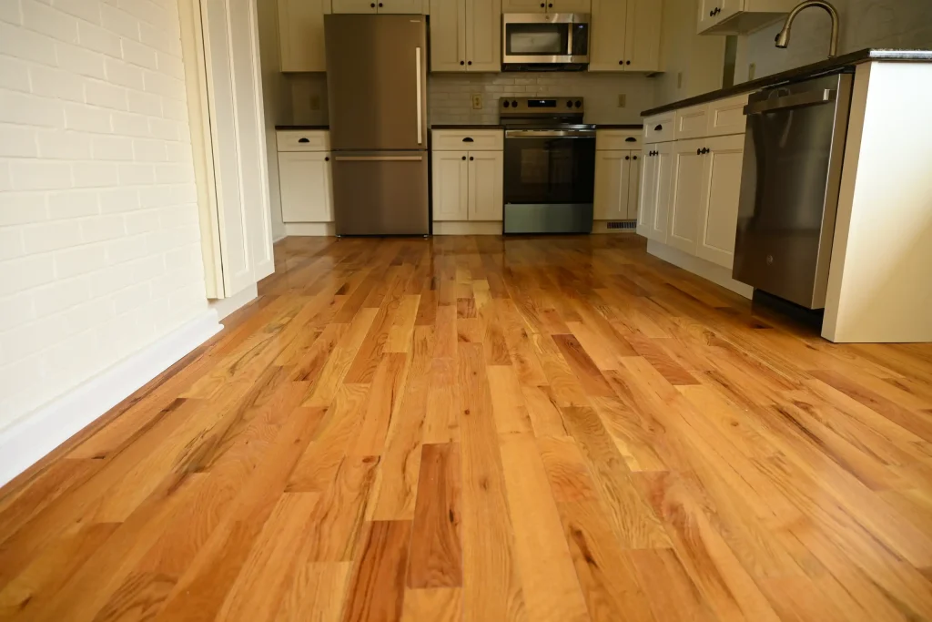 Character Golden Oak prefinished Red Oak flooring in a kitchen with white cabinets and stainless steel appliances.